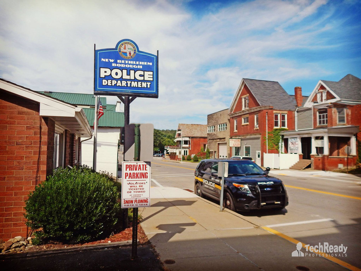 Police station sign and police vehicle on Broad Street in New Bethlehem